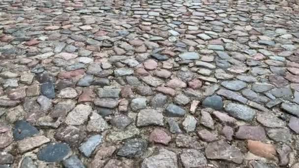 在古石板的路面上前行 古老的石材路面纹理 用混凝土和石头建造的小径 有一条竖井的人行道 — 图库视频影像