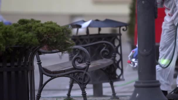 Feuerwehr Sprüht Öffentliche Bank Mit Desinfektionsmittel Auf Hauptplatz Der Stadt — Stockvideo