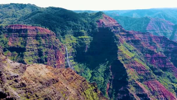 高清夏威夷考艾岛慢镜头从怀美亚峡谷俯冲下来 从远处的瀑布滑落到高高的草地上 — 图库视频影像