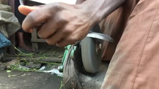 Detailní Záběr Ruky Nigerijského Muže Brousící Nůž Valivým Broušeným Kamenem — Stock video