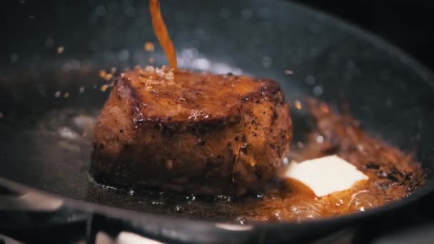 肉排的特写镜头 用黑色的牛油平底锅煎 番茄酱慢动作地倒入锅里 — 图库视频影像