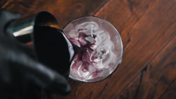 Barkeeper Mit Schwarzen Handschuhen Gießt Ein Lila Getränk Ein Glas — Stockvideo