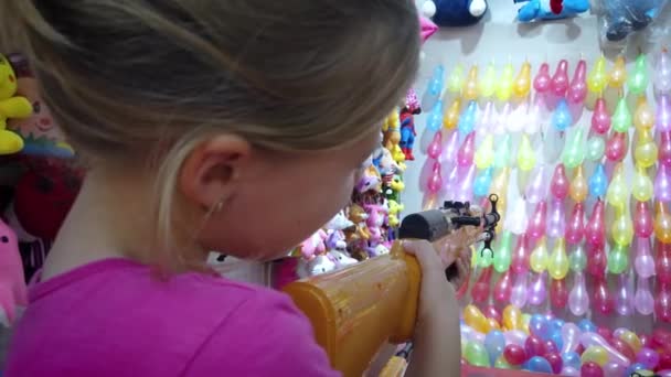 Joven Chica Caucásica Disparando Pistola Bala Goma Filas Globos Colores — Vídeos de Stock