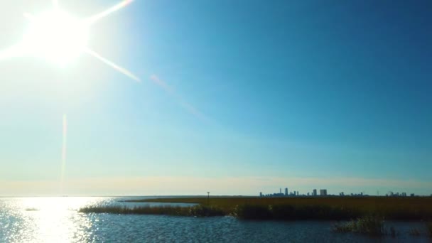在晴朗的天气里 4K斜视过去的太阳 在水道上反射出明亮的光芒 远处是亚特兰大市的天际线 相框相距很近 — 图库视频影像