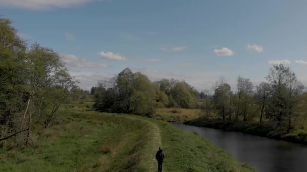 ドローン4K映像田園風景を背景に堤防の歩道を歩く男のクローバーデールとの距離で高速道路を明らかに — ストック動画