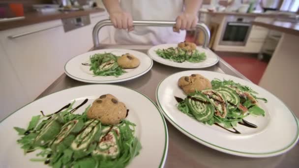 在厨房助理的推动下 用钢制购物车穿过餐厅厨房的饭菜 — 图库视频影像