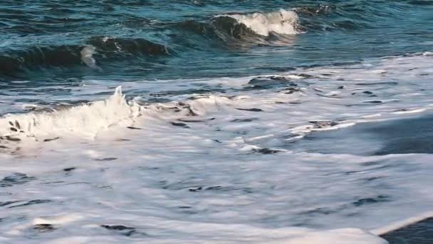 白い泡の上の驚くべきオレンジ色の輝きが海に戻ってくる間 砂浜での海の圧延から波 クローズアップスローモーションショット — ストック動画