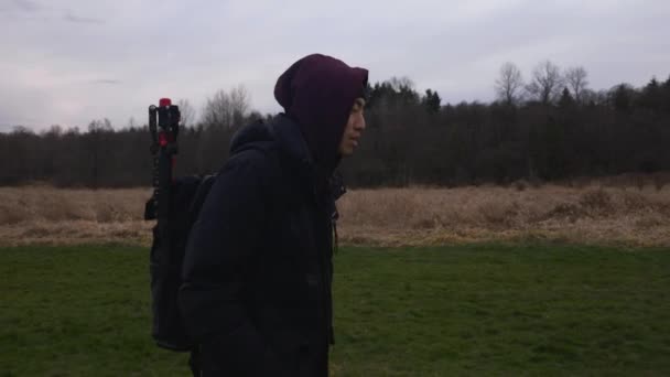 Parktaki Çim Tarlasında Yürüyen Bir Adamın Yan Görüntüsü Sırt Çantası — Stok video