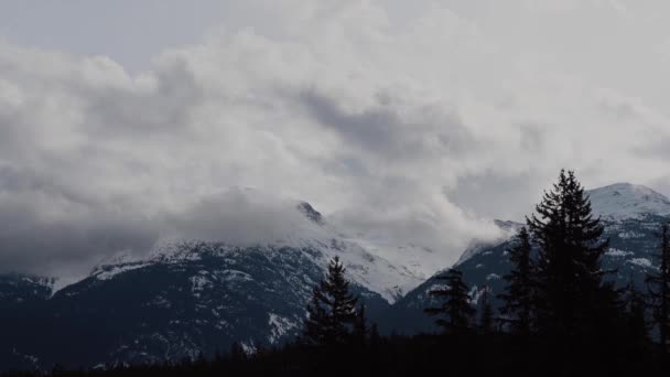 加拿大不列颠哥伦比亚省雪山上滚滚的云朵的时间流逝 — 图库视频影像