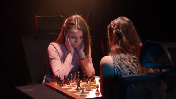 若い白人女性は女性のチェスゲームをプレイする次の動きについて考えています スタティックショット — ストック動画