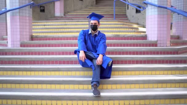 Masculino Graduado Senta Escola Seu Boné Vestido Com Máscara Facial — Vídeo de Stock