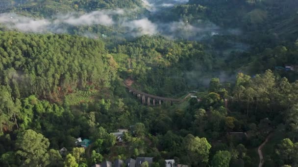 低い吊り下げ雲を持つ緑豊かなジャングルに囲まれた9つのアーチ橋の美しいユニークな空中 スリランカ — ストック動画