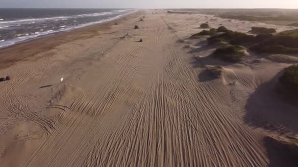 日没時に砂浜を走るサファリジープの空中ビュー Mar Las Pampas Argentina — ストック動画