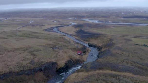 空の灰色の雲の間にアイスランドの壮大な風景の中に実行されているセラ川の空中ドローンショット — ストック動画