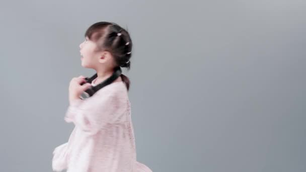 ヘッドフォンを持つかわいいアジアの女の子は 音楽とダンスを楽しんで スタジオで幸せに振り向く — ストック動画