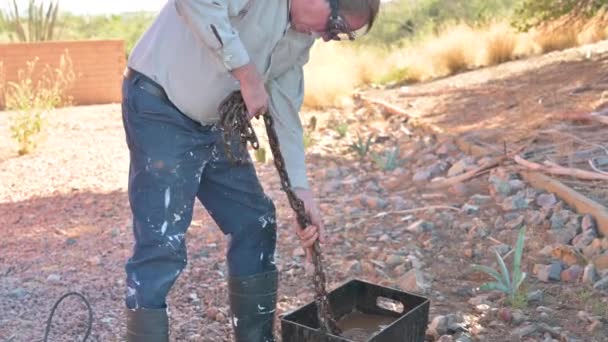 男工在户外用水桶清洗金属链条 — 图库视频影像
