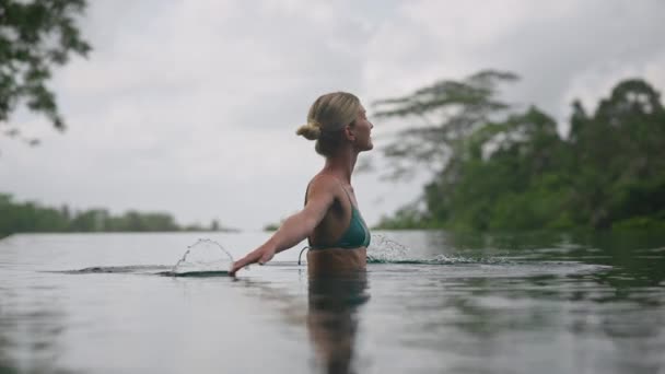 Élégante Femme Blonde Tourbillonnant Dans Piscine Éclaboussant Les Mains Dans — Video