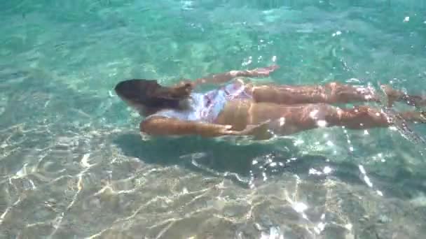 在热带海滩上 年轻女子在清澈的水里游着 慢动作 — 图库视频影像