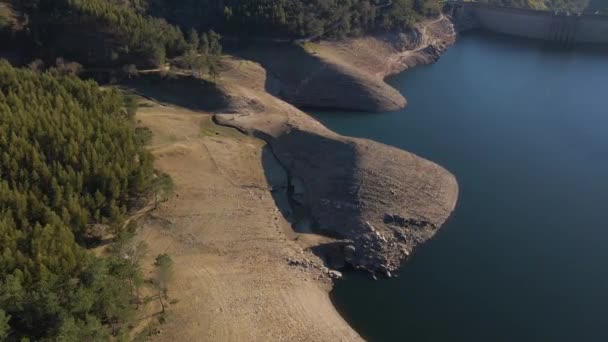 一个葡萄牙水坝的4K航景 飞越Barragem Cabril上空 无人驾驶飞机在河的右岸旋转 显示出背景上的一些绿色松树林 — 图库视频影像