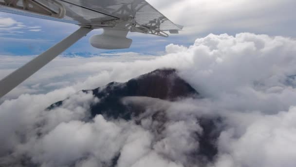 在浓密的云彩之上可以看到山顶 从巴布亚新几内亚山区的一架小飞机上俯瞰 第二部影片 — 图库视频影像