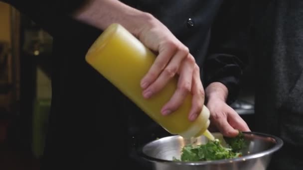 주방에서 샐러드를 만드는 직업적 요리사가 스테인리스강 혼합물 용기에 샐러드를 추가하여 — 비디오