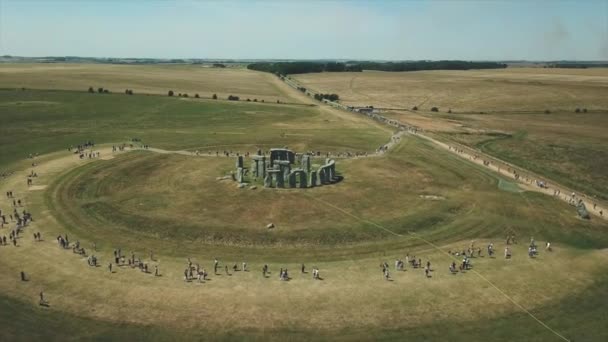 観光客に囲まれた英国のストーンヘンジ記念碑のオービット航空 — ストック動画