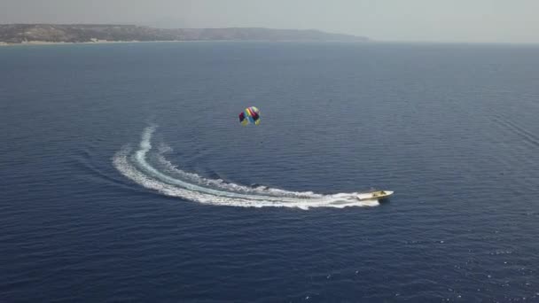 Τουρίστες Απολαμβάνουν Πολύχρωμο Parasail Βόλτα Πίσω Από Τουριστικό Σκάφος Μπλε — Αρχείο Βίντεο