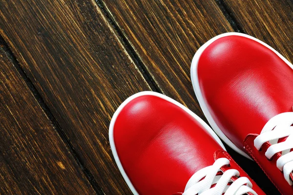 Červené boty na dřevěném pozadí — Stock fotografie