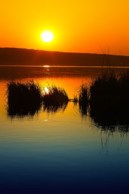 Güzel gün batımı sakin göl üzerinde. Alacakaranlık saat