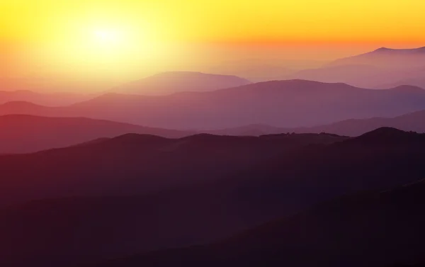 Gün batımında dağ eteklerindeki siluetleri — Stok fotoğraf