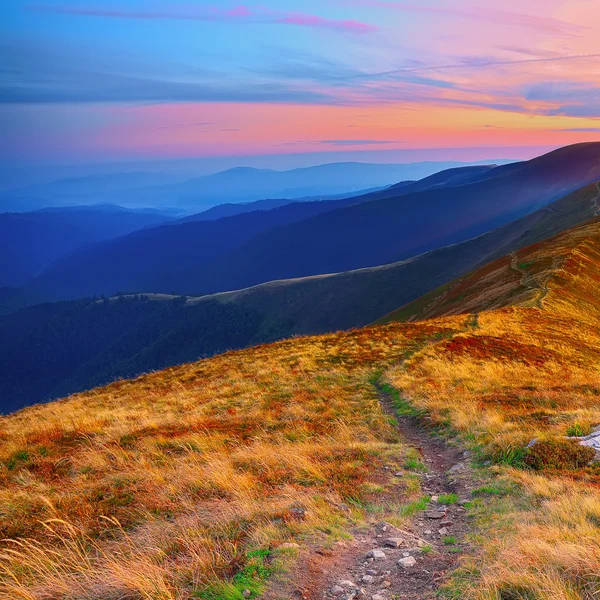 çayırlar batımında dağ aralığının üzerinden dolambaçlı yol