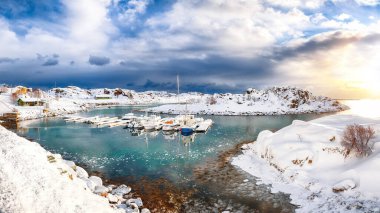 Küçük bir balıkçı köyünde yatları ve tekneleri olan muhteşem kış manzarası ve Valberg yakınlarındaki karlı dağ zirveleri. Konum: Valberg, Vestvagoy, Lofotens, Norveç