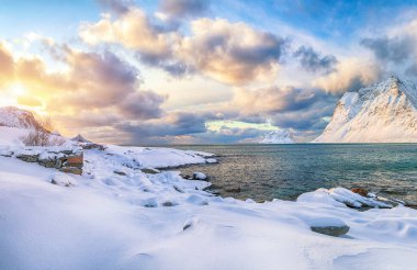 Gün batımında Vik sahilinin muhteşem kış manzarası. Leknes yakınlarında bir sürü kar ve karlı dağ tepeleri var. Konum: Leknes, Vestvagoy, Lofotens, Norveç
