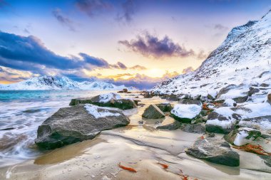 Güneş batarken Haukland sahilinin muhteşem kış manzarası. Leknes yakınlarında çok kar ve karlı dağ zirveleri var. Konum: Leknes, Vestvagoy, Lofotens, Norveç