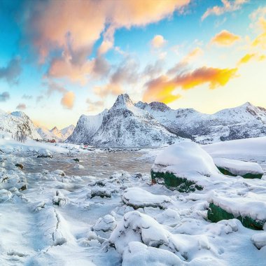 Picturesque donmuş Flakstadpolen ve Boosen fiyortlarında güneş doğarken buzda çatlaklar ve Hustinden Dağı arka planda. Konum: Flakstadoya Adası, Lofoten; Norveç, Avrupa