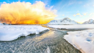 Skagsanden plajında güneş doğarken parlayan bulutlarla muhteşem bir kış manzarası. Popüler turizm merkezi. Konum: Flakstadoya Adası, Lofoten; Norveç, Avrupa