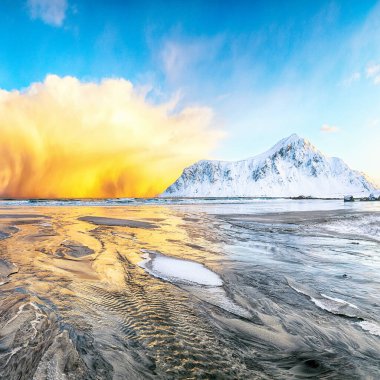 Skagsanden plajında güneş doğarken parlayan bulutlarla muhteşem bir kış manzarası. Popüler turizm merkezi. Konum: Flakstadoya Adası, Lofoten; Norveç, Avrupa