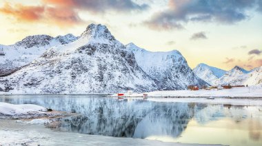 Fevkalade donmuş Flakstadpolen ve Boosen fiyortları ve gündoğumunda sudaki yansıma ve Hustinden dağı arka planda. Konum: Flakstadoya Adası, Lofoten; Norveç, Avrupa