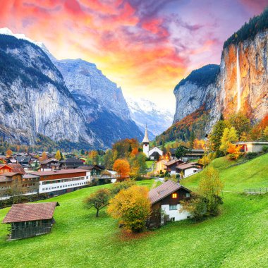 Gün batımında muhteşem Staubbach şelalesi ve İsviçre Alpleri ile Lauterbrunnen Vadisi 'nin dramatik sonbahar manzarası. Konum: Lauterbrunnen Köyü, Berner Oberland, İsviçre, Avrupa.