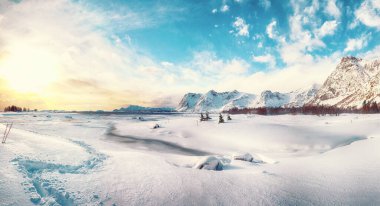 Gün batımında Vestvagoy Adası 'nda donmuş fiyortlu kış manzarası ve Valberg yakınlarında karlı dağ zirveleri. Konum: Valberg, Vestvagoy, Lofotens, Norveç
