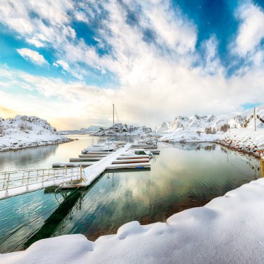 Küçük bir balıkçı köyünde yatları ve tekneleri olan büyüleyici kış manzarası ve Valberg yakınlarındaki karlı dağ zirveleri. Konum: Valberg, Vestvagoy, Lofotens, Norveç