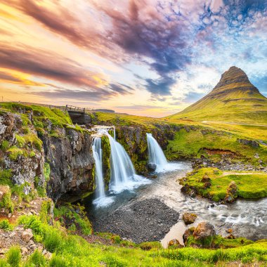 Gün batımında Kirkjufellsfoss Şelalesi 'nin yanında dramatik bir manzara. Konum: Kirkjufellsfoss, Grundarfjordurn, İzlanda, Avrupa