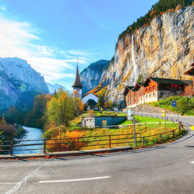 Arka planda muhteşem şelale Staubbach ve İsviçre Alpleri ile Lauterbrunnen köyünün göz kamaştırıcı sonbahar manzarası. Konum: Lauterbrunnen Köyü, Berner Oberland, İsviçre, Avrupa.