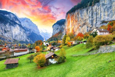 Gün batımında muhteşem Staubbach şelalesi ve İsviçre Alpleri ile Lauterbrunnen Vadisi 'nin büyüleyici sonbahar manzarası. Konum: Lauterbrunnen Köyü, Berner Oberland, İsviçre, Avrupa.