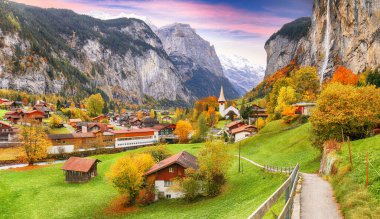 Ünlü kilisesi ve Staubbach şelalesiyle turistik alp köyü Lauterbrunnen 'in muhteşem sonbahar manzarası. Konum: Lauterbrunnen Köyü, Berner Oberland, İsviçre, Avrupa.