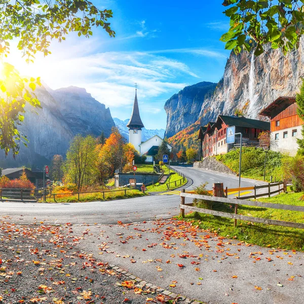 Stunning autumn view of Lauterbrunnen village with alpine, alps, architecture, attraction, amazing, autumn, background, beautiful, branch, building, church, colorful, cliff, destination, fall, foliage, garden,  holiday, house, journey, landmark, land