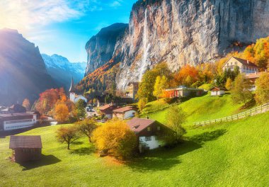 Arka planda muhteşem şelale Staubbach ve İsviçre Alpleri olan Lauterbrunnen köyünün fantastik sonbahar manzarası. Konum: Lauterbrunnen Köyü, Berner Oberland, İsviçre, Avrupa.