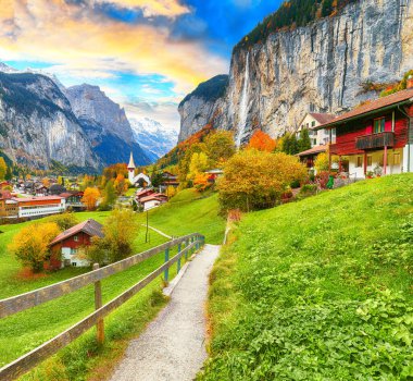 Arka planda muhteşem Staubbach şelalesi ve İsviçre Alpleri olan Lauterbrunnen Vadisi 'nin şaşırtıcı sonbahar manzarası. Konum: Lauterbrunnen Köyü, Berner Oberland, İsviçre, Avrupa