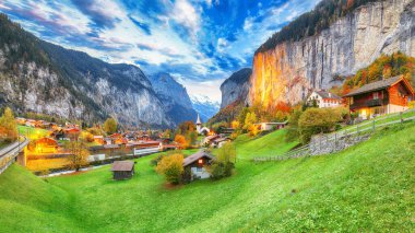 Gün batımında muhteşem Staubbach şelalesi ve İsviçre Alpleri ile Lauterbrunnen Vadisi 'nin dramatik sonbahar manzarası. Konum: Lauterbrunnen Köyü, Berner Oberland, İsviçre, Avrupa.