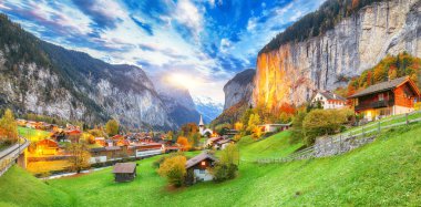 Gün batımında muhteşem Staubbach şelalesi ve İsviçre Alpleri ile Lauterbrunnen Vadisi 'nin dramatik sonbahar manzarası. Konum: Lauterbrunnen Köyü, Berner Oberland, İsviçre, Avrupa.